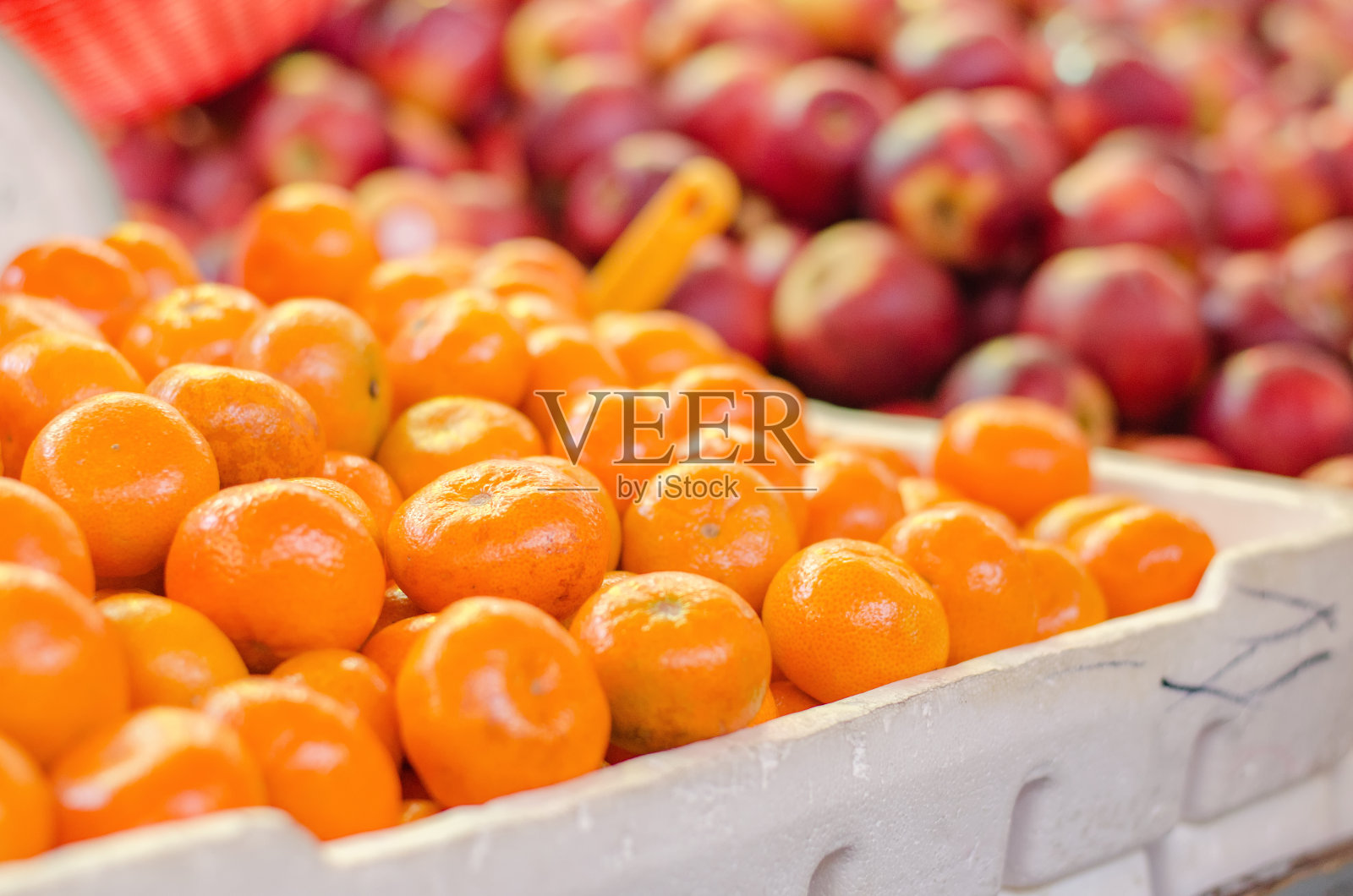 美丽的颜色组合，橙色和红色的苹果背景显示在市场摊位。照片摄影图片