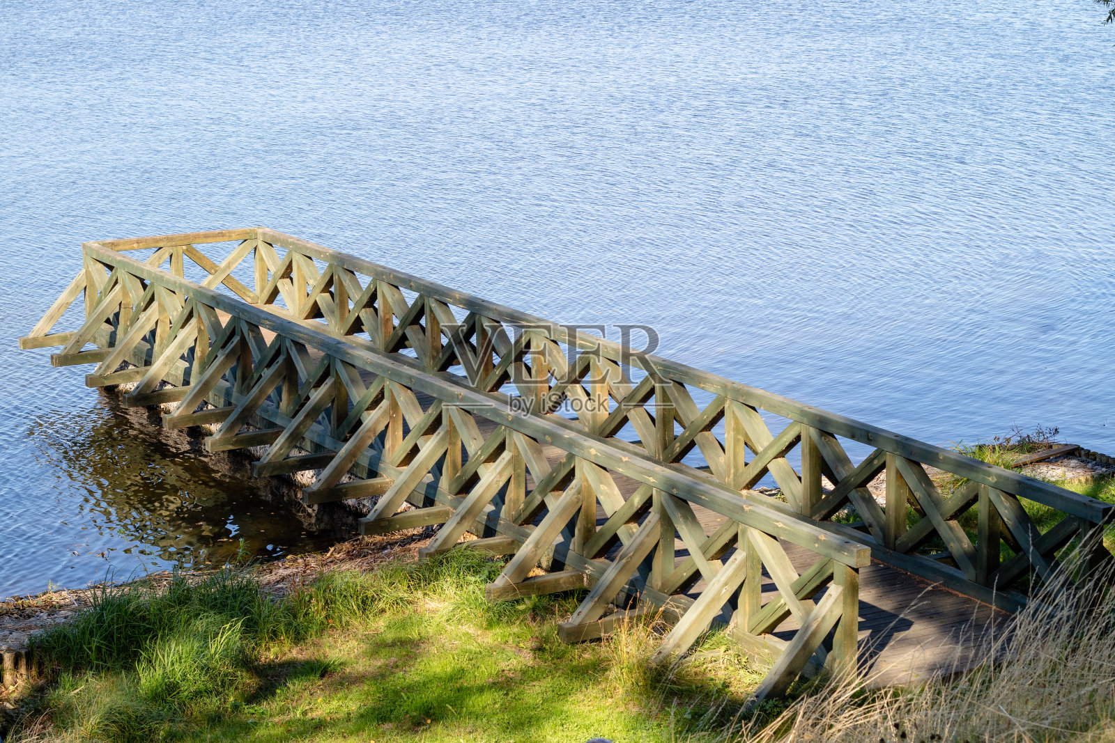 湖上的一座旧桥。停泊船的地方。秋天的季节。照片摄影图片