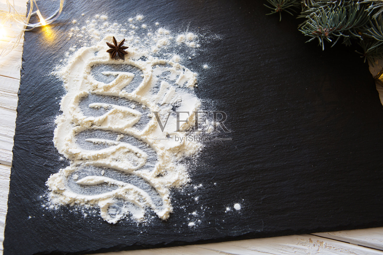 以面粉和八角香料作为装饰的圣诞树在黑色的石头背景照片摄影图片