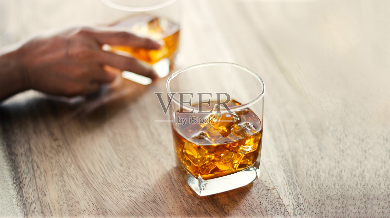 特写镜头。在酒吧柜台，人们和一杯威士忌一起喝酒精饮料照片摄影图片