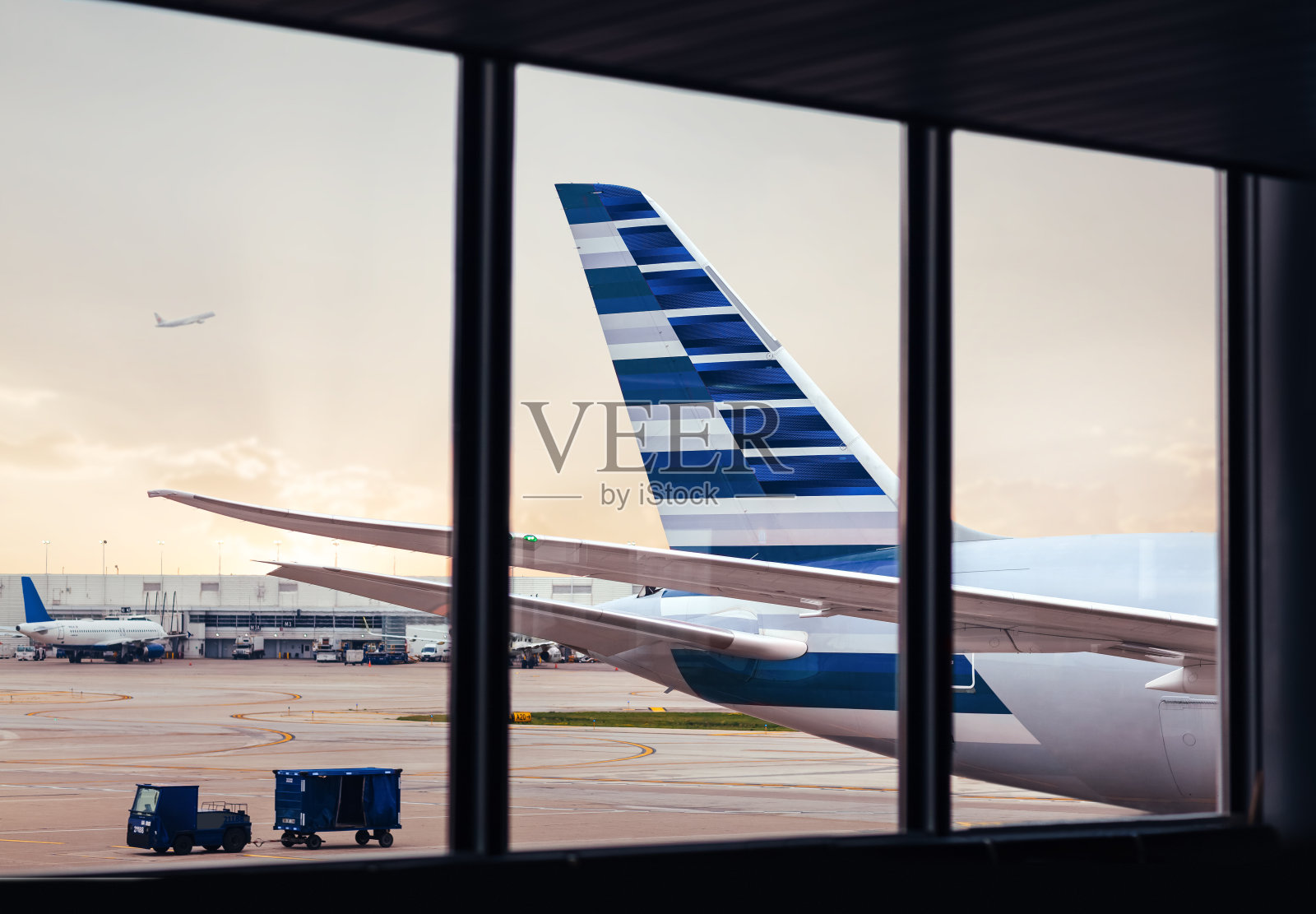 通过机场窗口观察飞机机身尾部与货物照片摄影图片