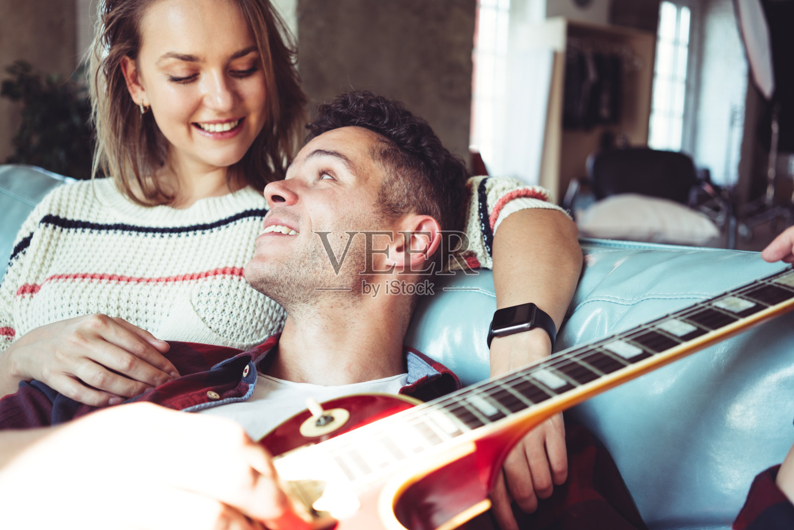 家庭生活。夫妇在家里用电吉他照片摄影图片