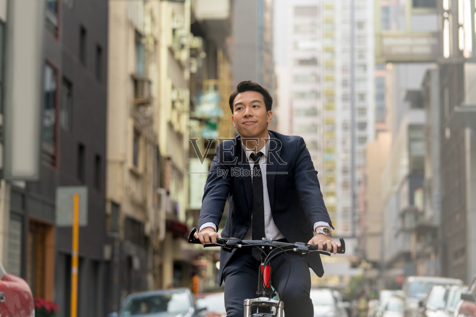 商人骑着自行车穿过城市照片摄影图片