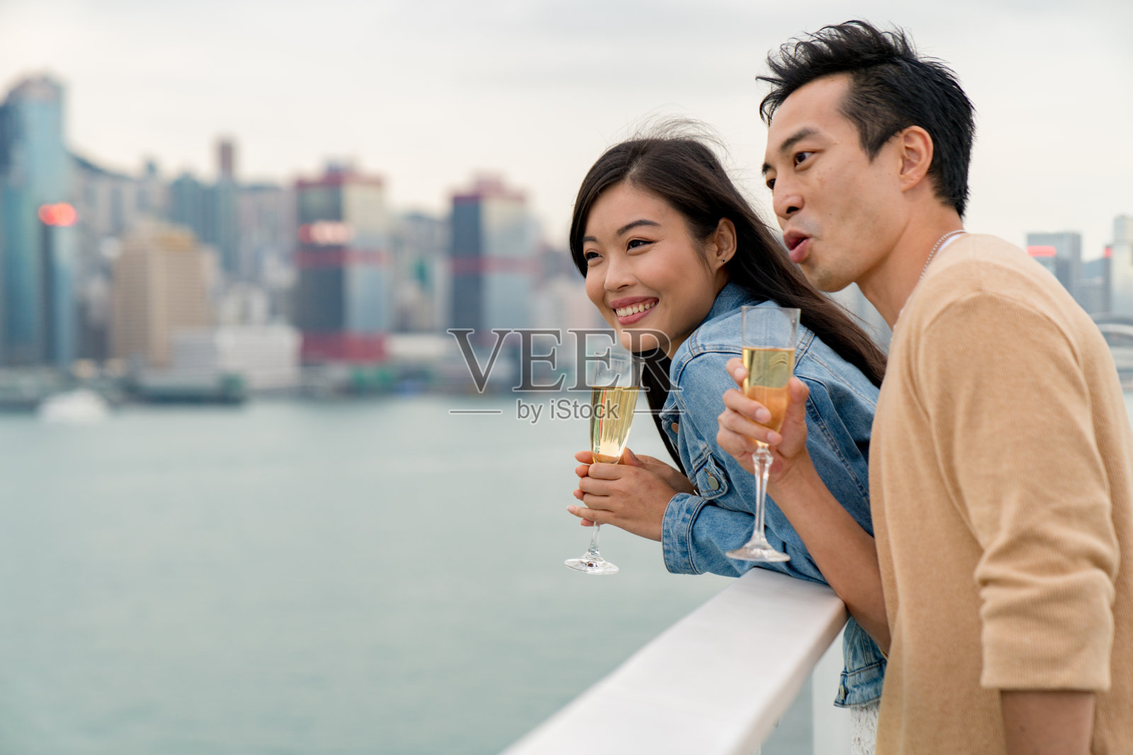 年轻夫妇在海港城欣赏香港的天际线照片摄影图片