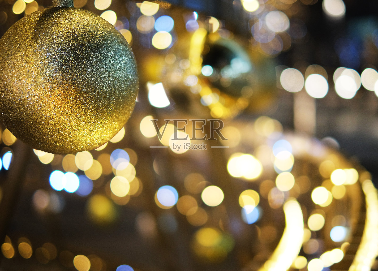 圣诞装饰背景用金色的彩灯发光。照片摄影图片