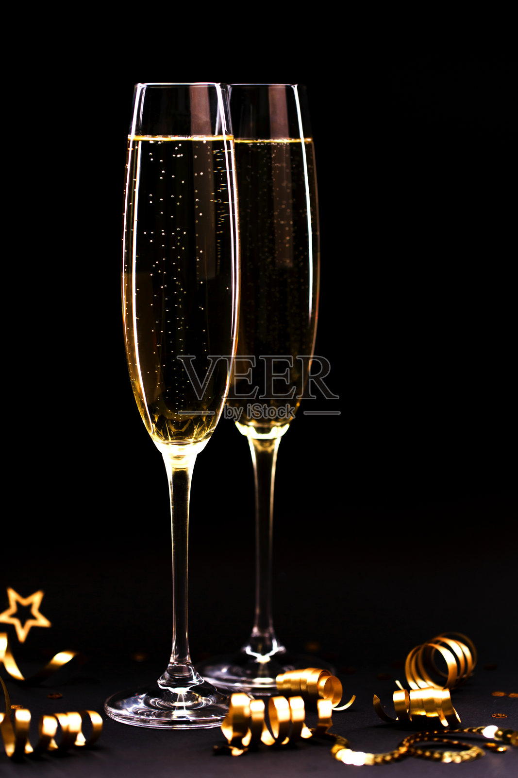 两杯大杯香槟，背景是黑色。照片摄影图片