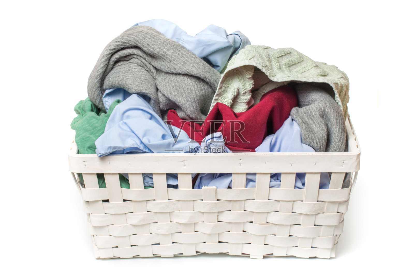 衣服放在洗衣木篮子里，以白色为背景照片摄影图片