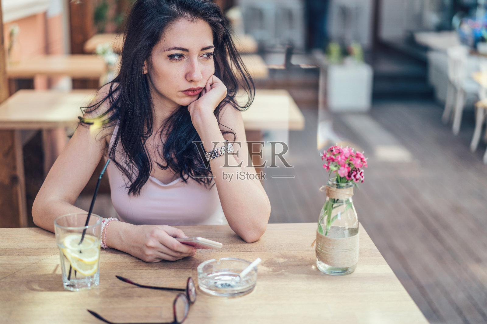 年轻悲伤的女人在café等着照片摄影图片