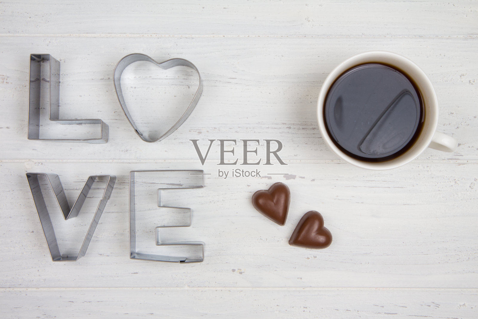 “爱”这个词。黑咖啡，牛奶巧克力。白色木制背景照片摄影图片