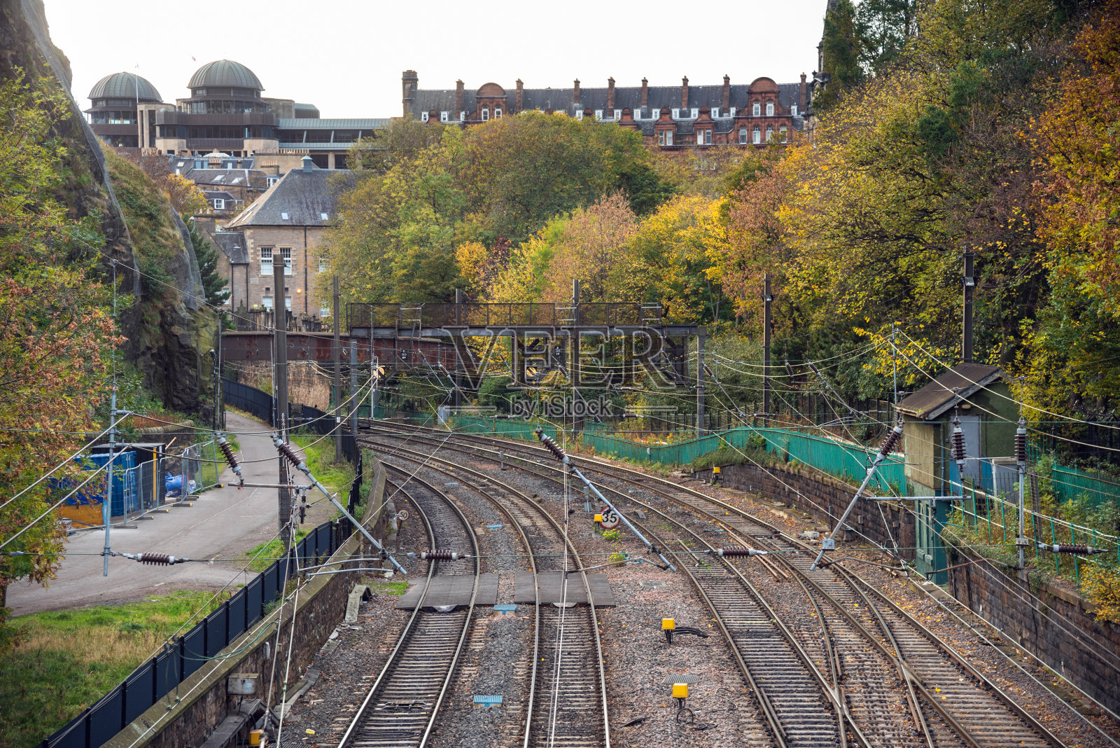 秋天，废弃的铁轨上排列着五颜六色的树木照片摄影图片