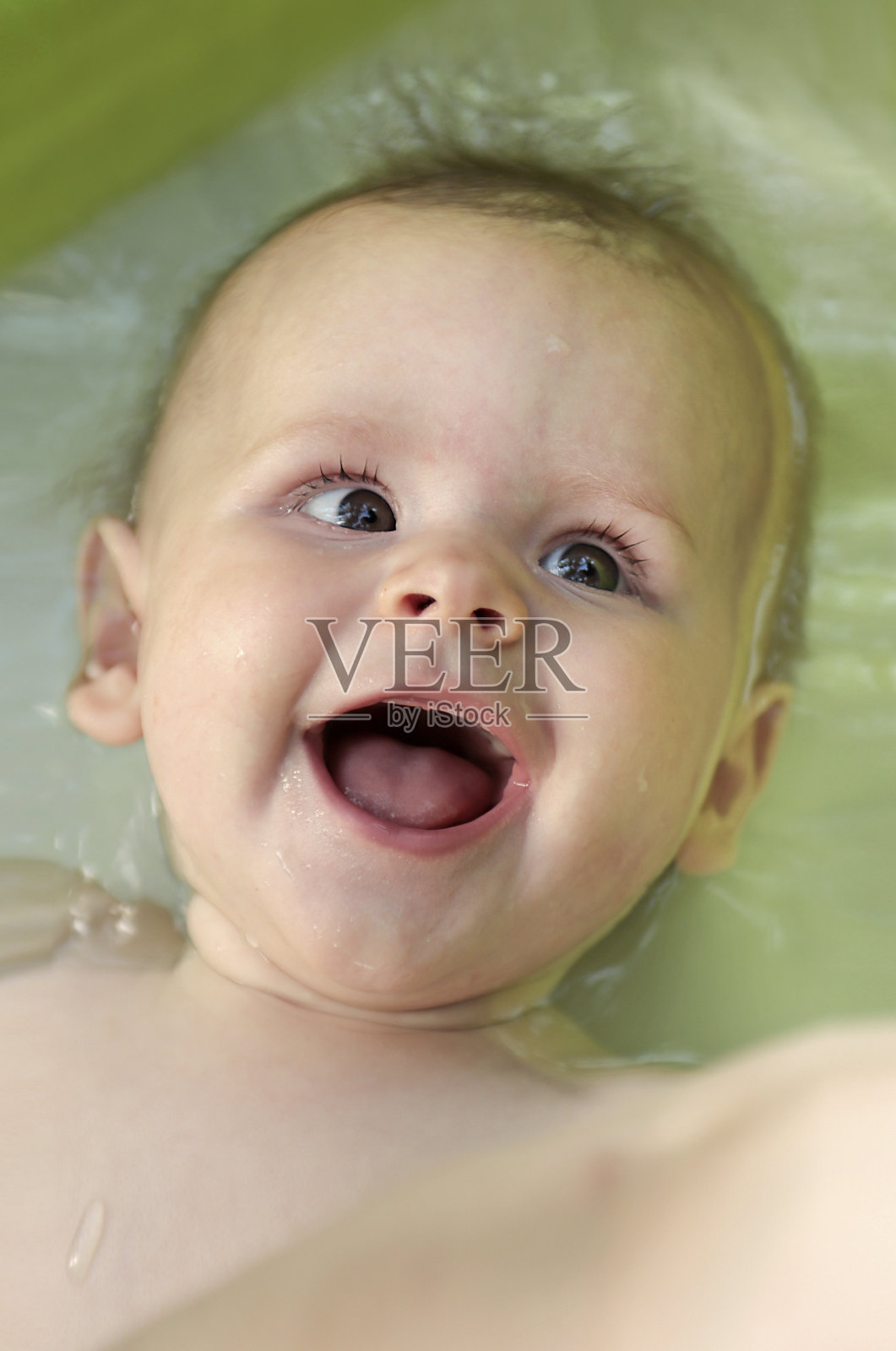 一个快乐的婴儿在儿童游泳池游泳的肖像照片摄影图片