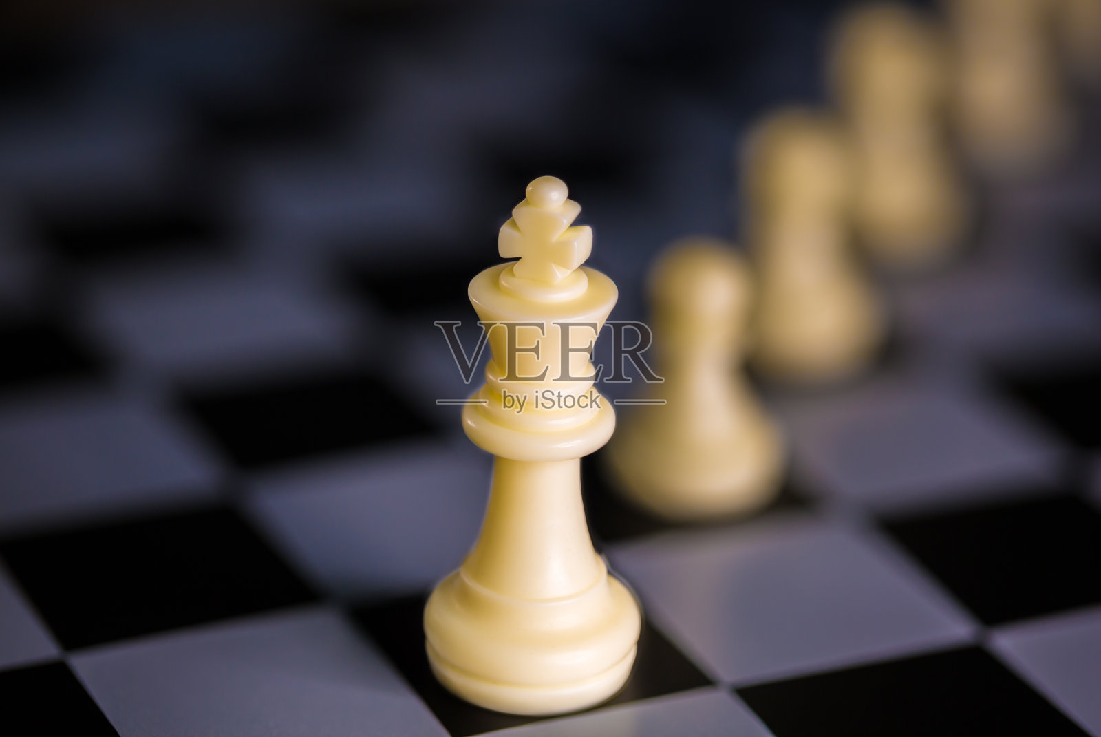 企业领导团队概念，白王棋在棋盘上领先白兵棋照片摄影图片