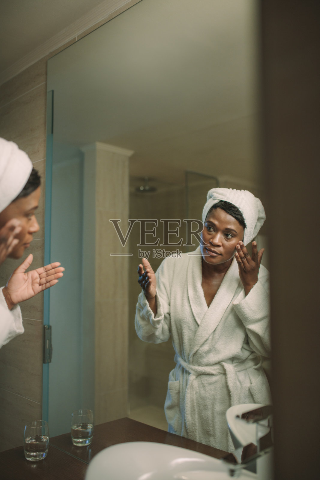 成熟女人在镜子里涂抹面霜的映像照片摄影图片
