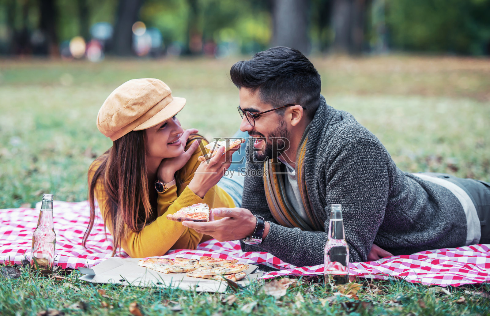 野餐。一对美丽的年轻夫妇在公园里玩。生活方式，爱情，约会概念照片摄影图片