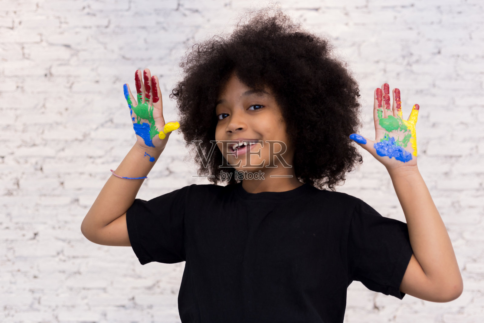 非裔美国人顽皮和创造性的孩子得到手脏与许多颜色-在白色孤立的背景。照片摄影图片