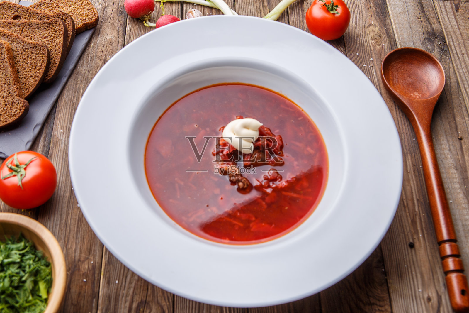 甜菜汤在白色盘子与蔬菜照片摄影图片