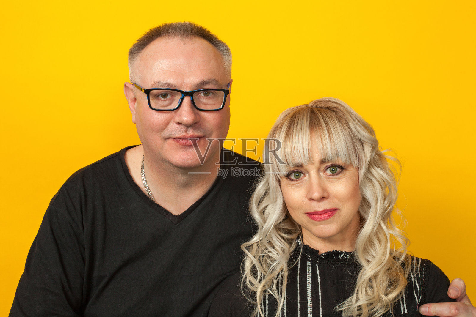 黄色背景上的一对成熟异性恋夫妇的工作室肖像照片摄影图片