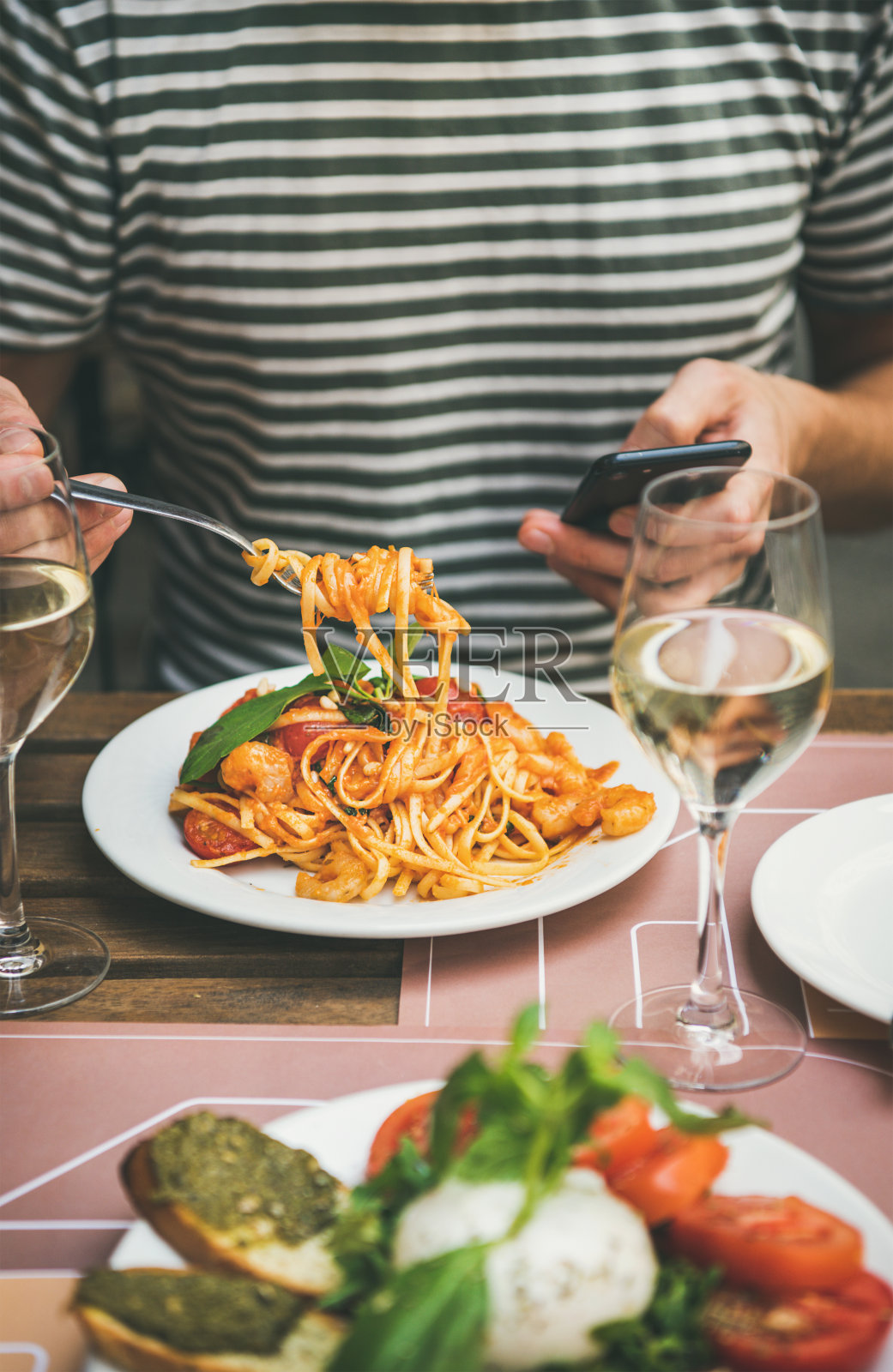 在小酒馆吃意大利晚餐，配意大利酱和意大利面配虾仁照片摄影图片