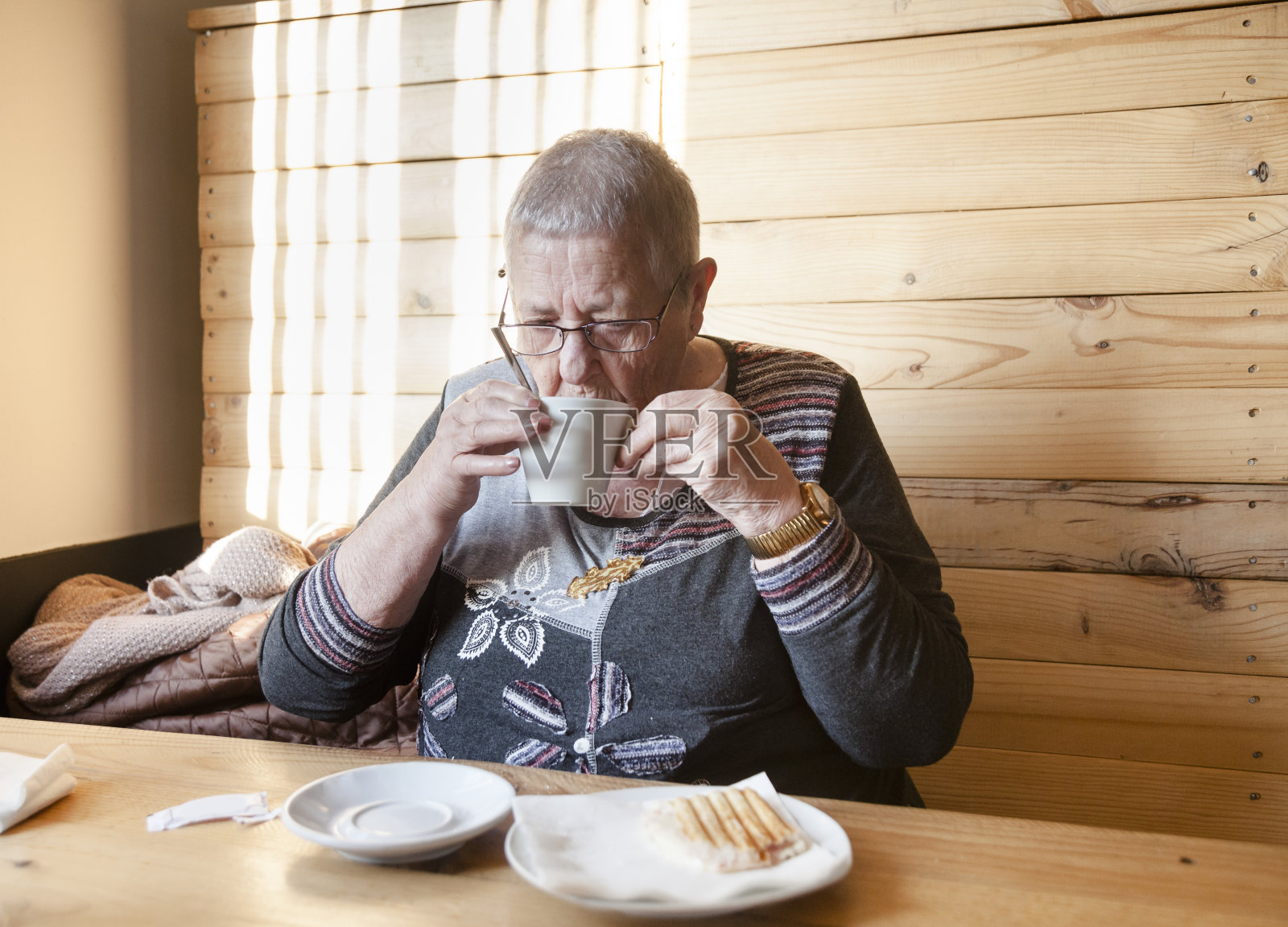 老妇人在吃三明治照片摄影图片