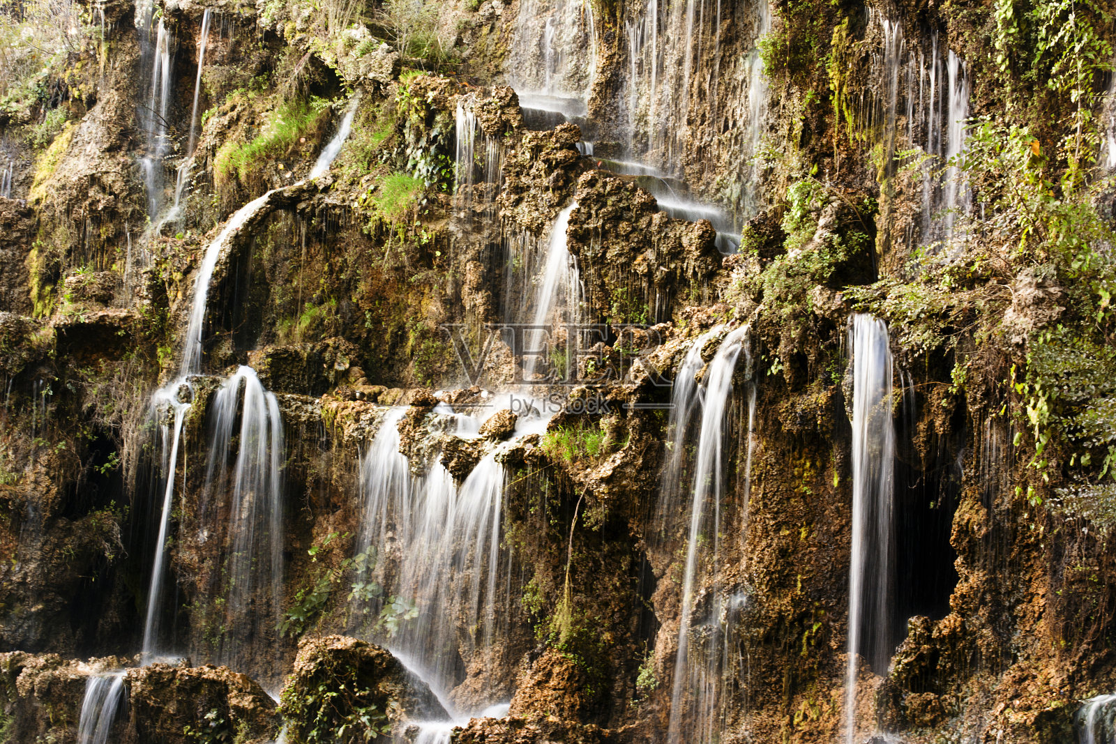 许多小瀑布从山上流下来。照片摄影图片