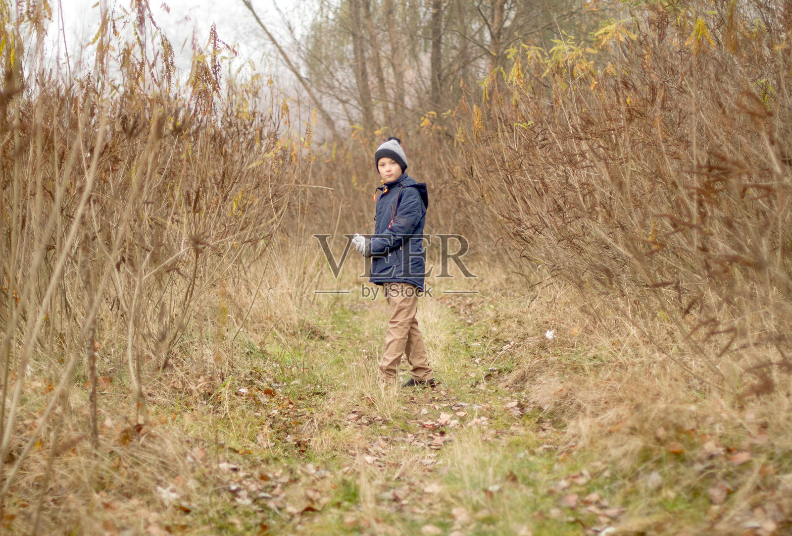 孩子在森林里迷路了。小男孩在森林里迷了路。悲伤的男孩独自穿过森林照片摄影图片