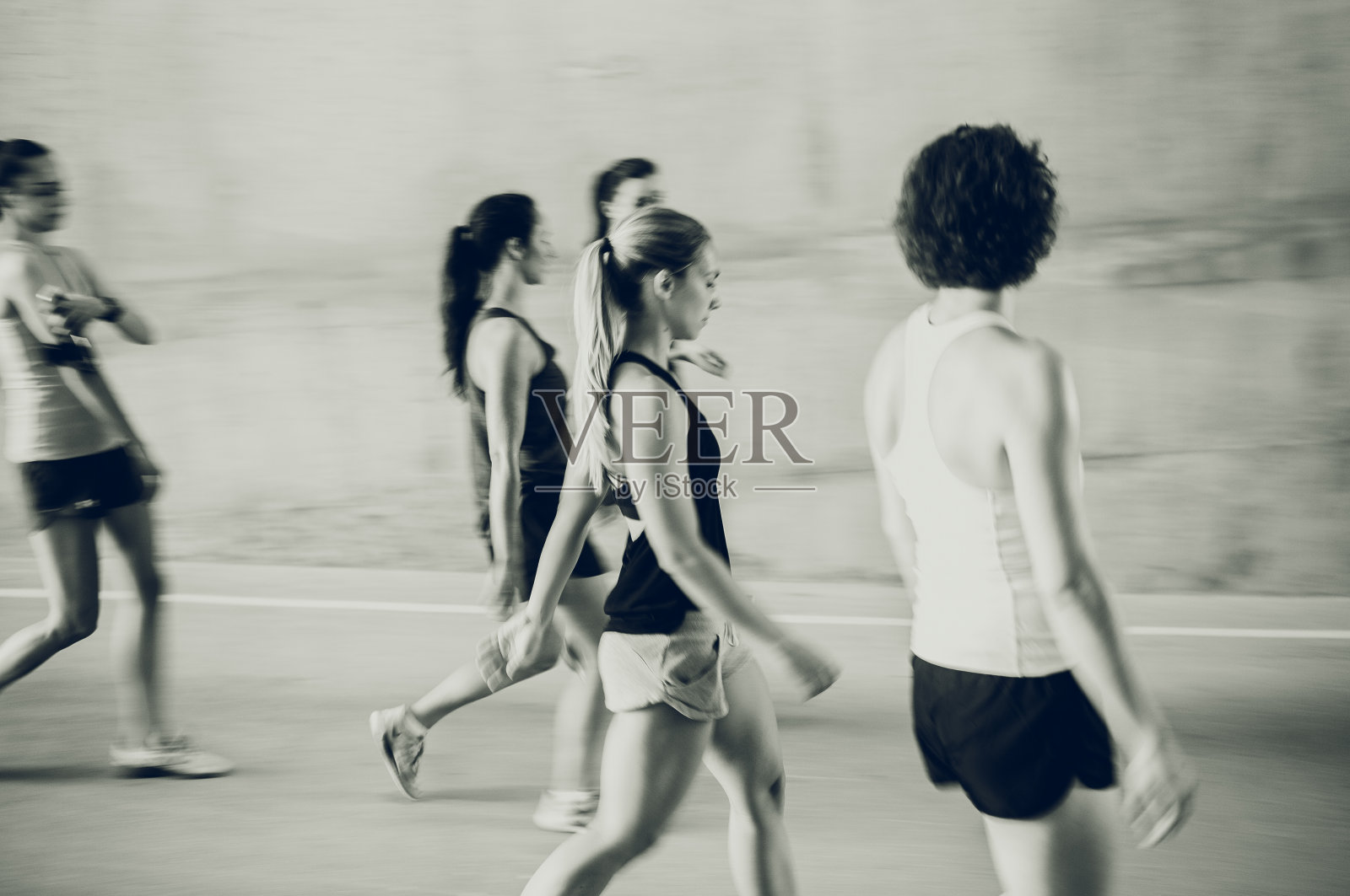 一群在街上奔跑的年轻女孩，模糊的动作照片摄影图片