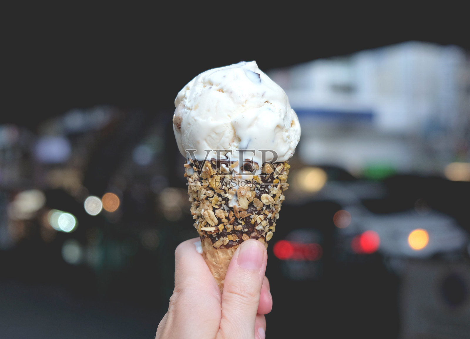手握香草冰淇淋在城市里照片摄影图片