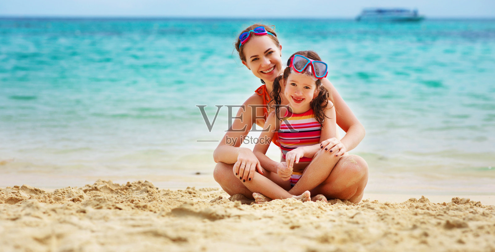 快乐的家庭妈妈和孩子戴着面具在夏天的海滩上照片摄影图片