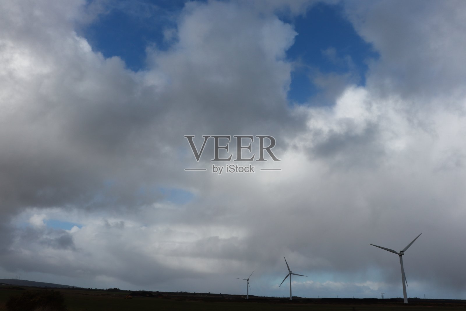 风力涡轮机在田野下戏剧性的天空与云彩照片摄影图片