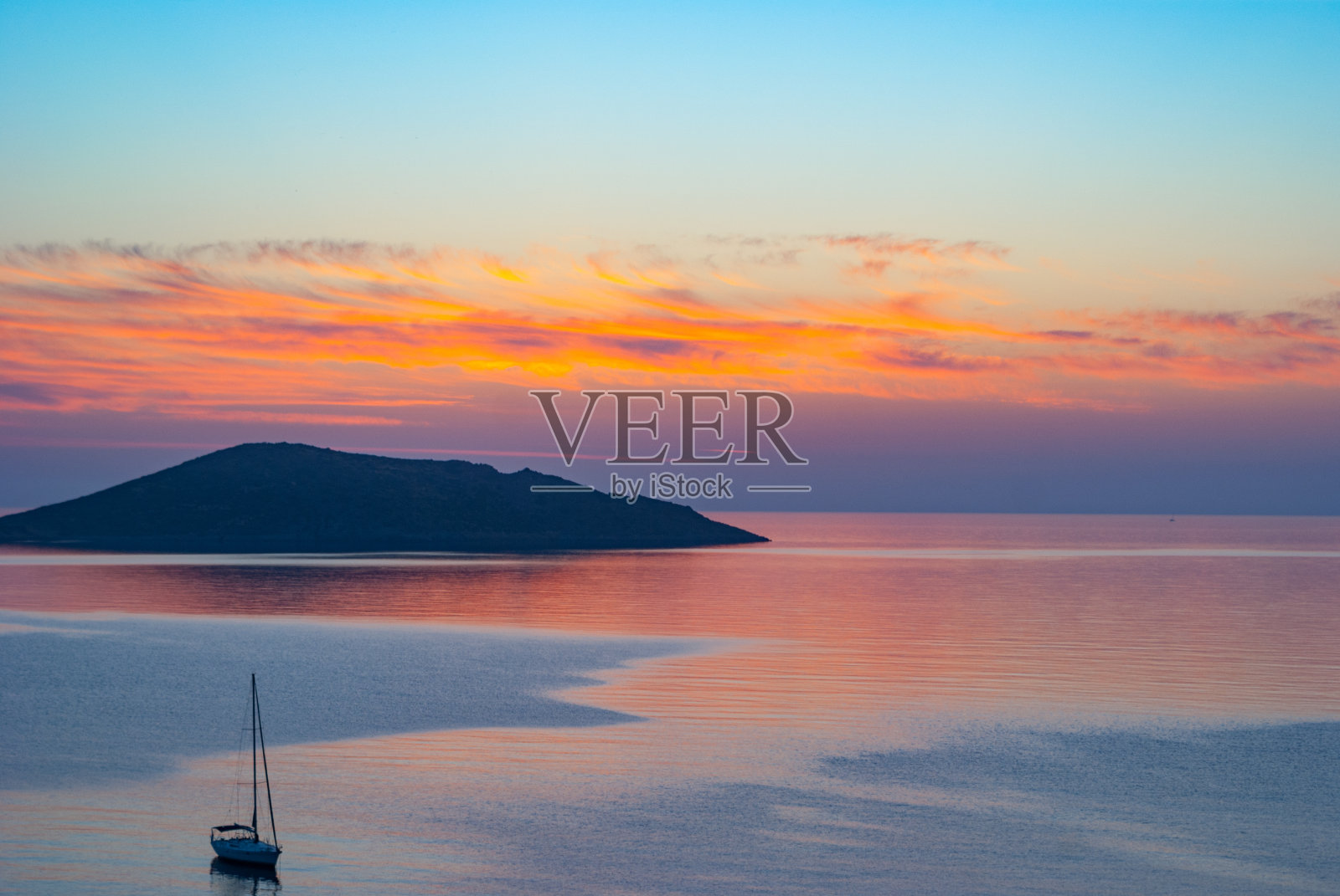 美丽的日落在水上，帆船和岛屿的背景照片摄影图片