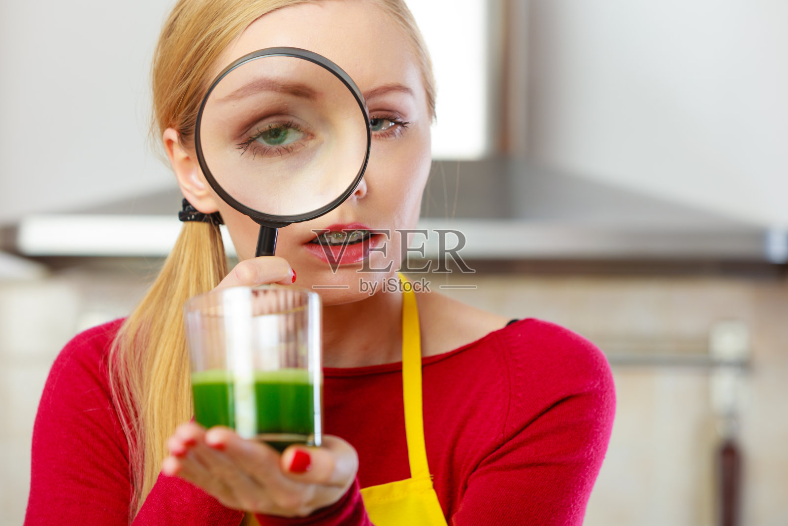 透过放大镜看蔬菜汁的女人照片摄影图片
