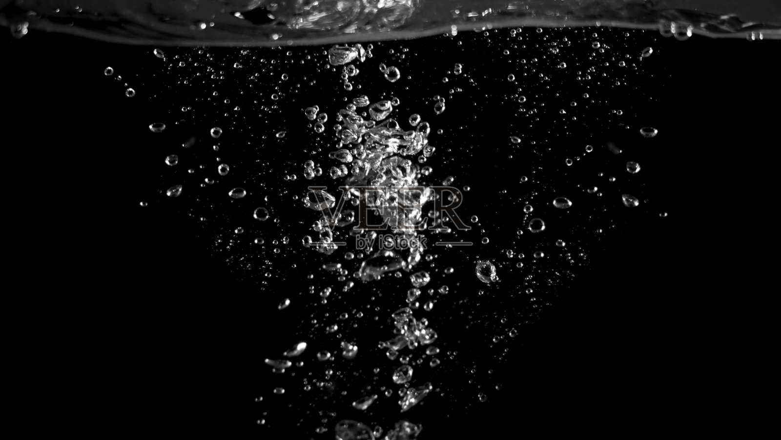 黑色背景中模糊的苏打水气泡、碳酸饮料或油状或啤酒嘶嘶作响、溅起和漂浮的水滴代表着闪闪发光和清爽照片摄影图片