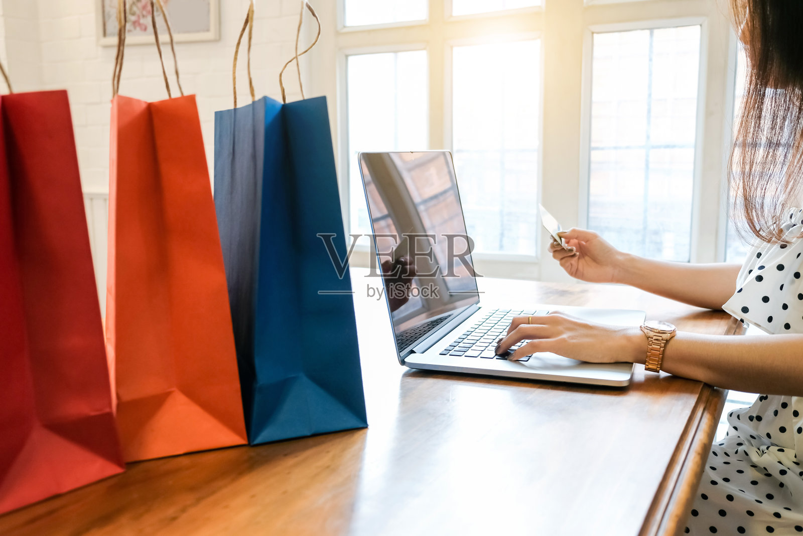 年轻女子使用笔记本电脑和信用卡。网上订购。网上购物的概念。照片摄影图片