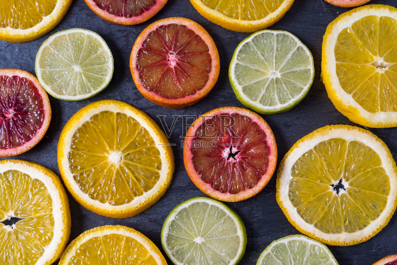 平铺切片不同的新鲜生柑橘类水果。照片摄影图片