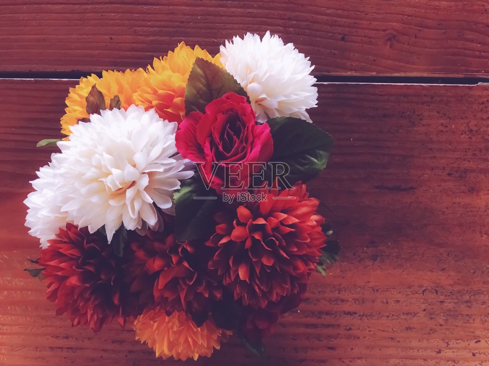 红玫瑰、黄、白、褐花，以木色为背景照片摄影图片