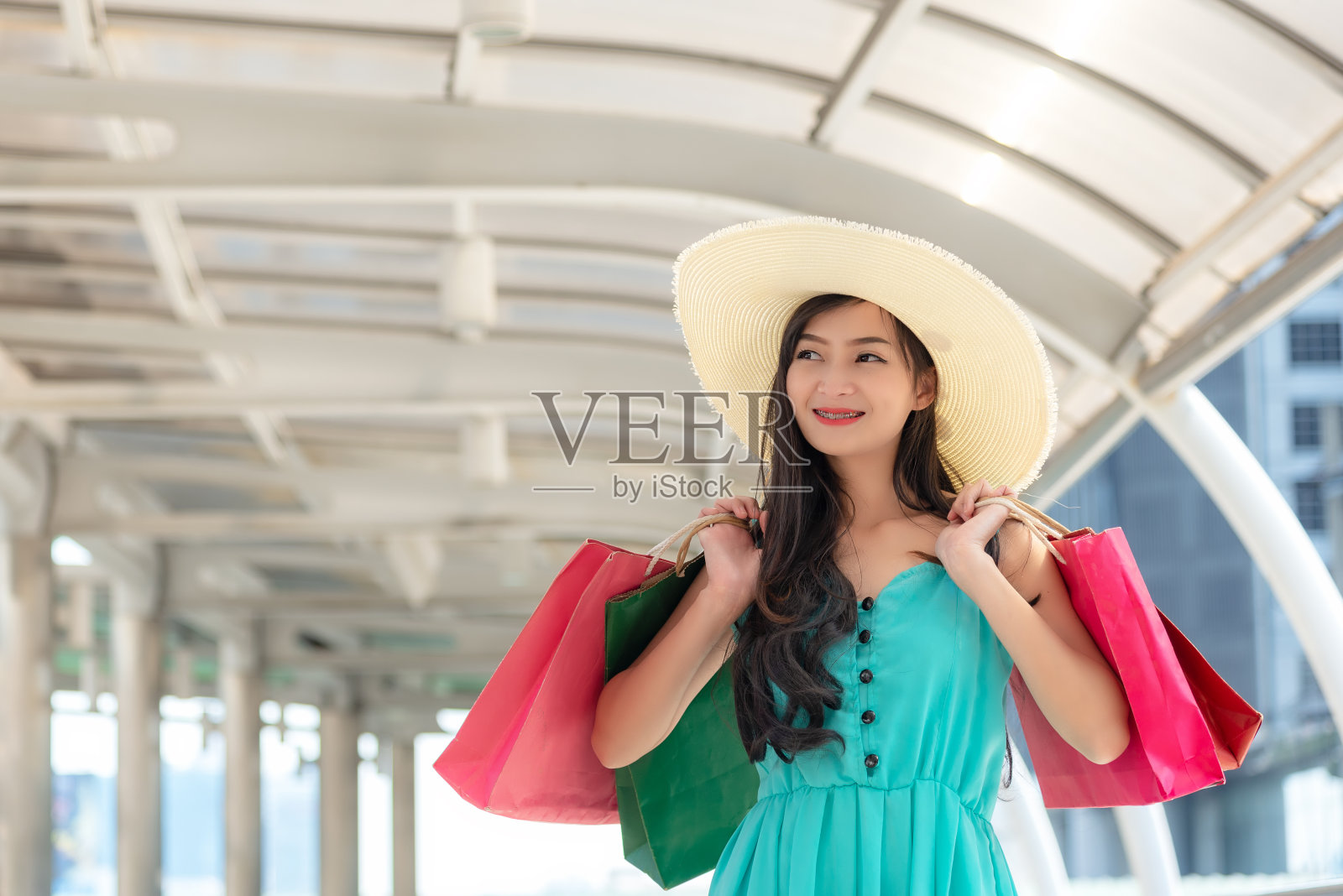 亚洲微笑的生活方式女子所以快乐购物在休闲服装与购物袋在模型塔购物中心。生活方式的概念照片摄影图片