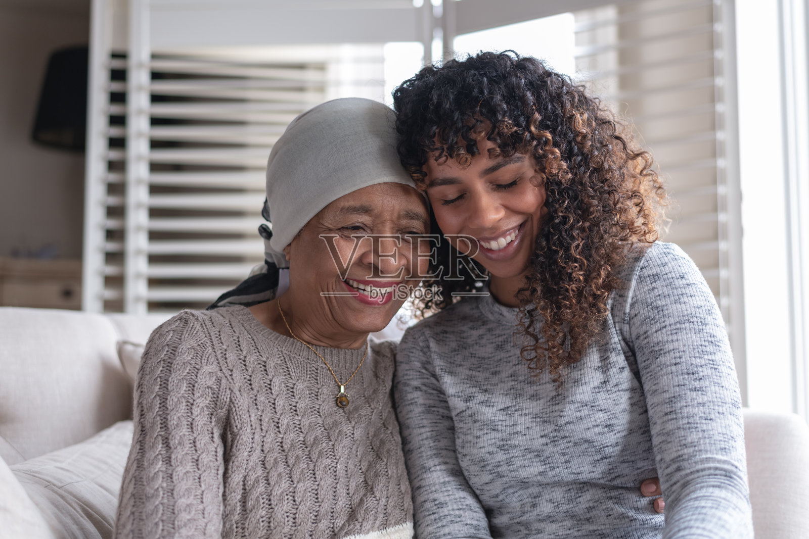 一位身患癌症的老妇人和她的女儿坐在一起照片摄影图片
