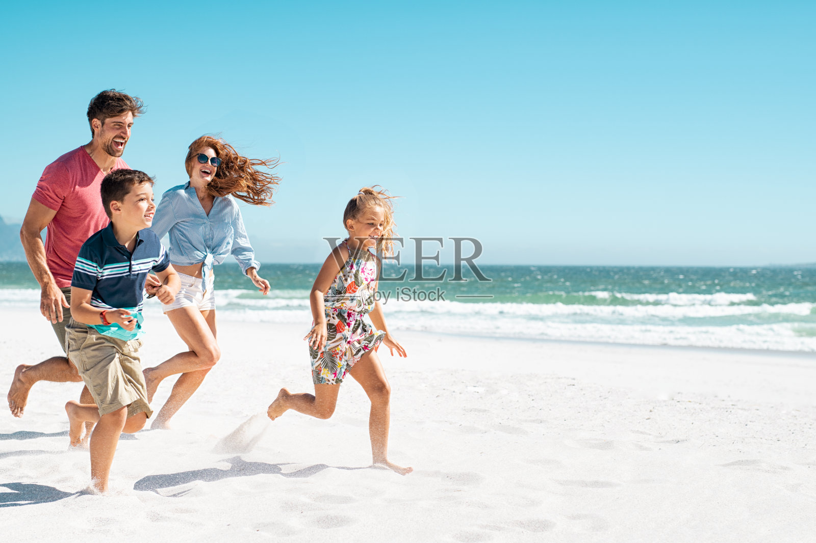 快乐的家庭在海滩上跑步照片摄影图片