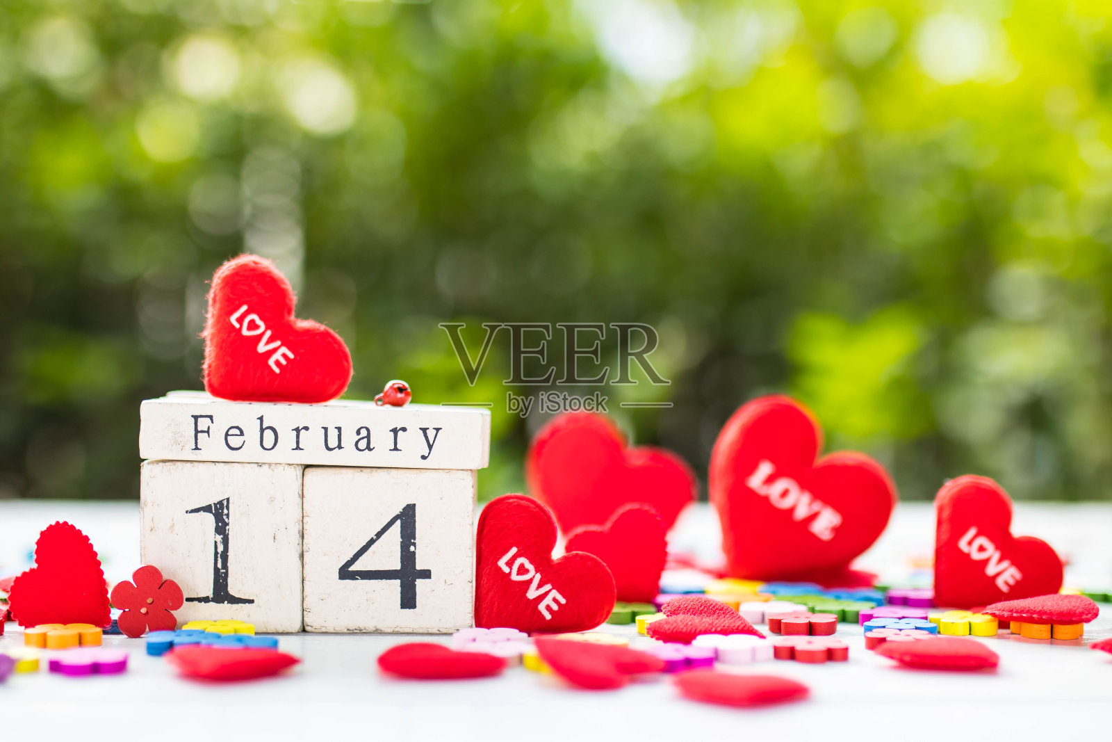 木制日历显示2月14日是情人节，周围还有红心照片摄影图片