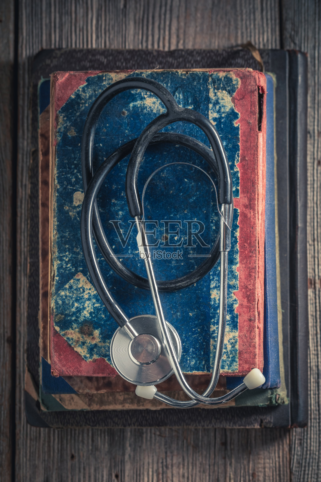 古董听诊器放在一堆旧书上照片摄影图片
