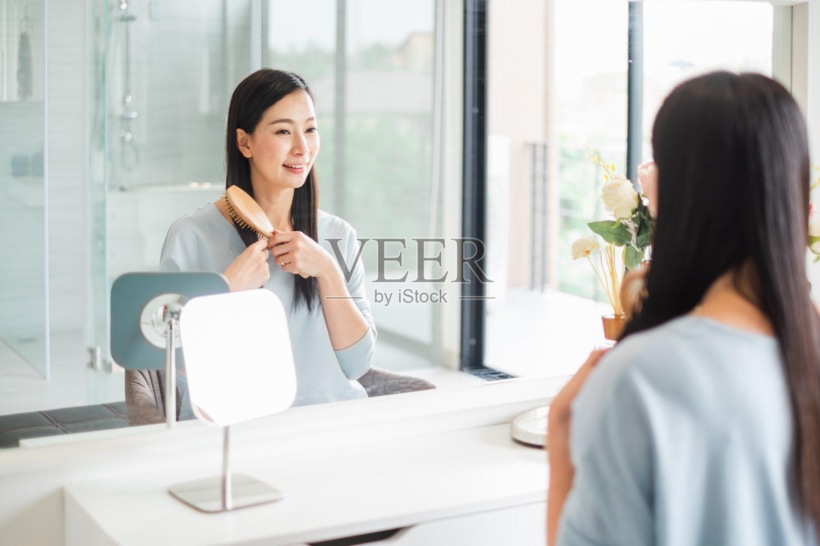 美丽的亚洲女人梳头前镜照片摄影图片