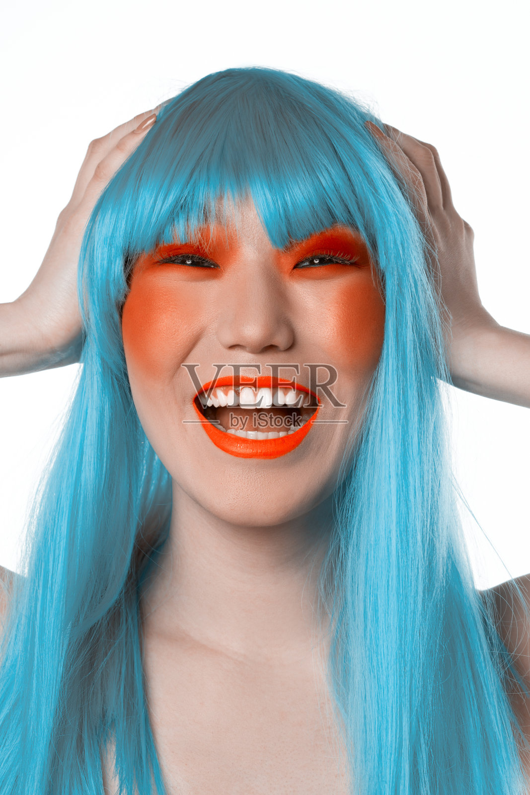 年轻的笑亚洲女人在蓝色假发照片摄影图片