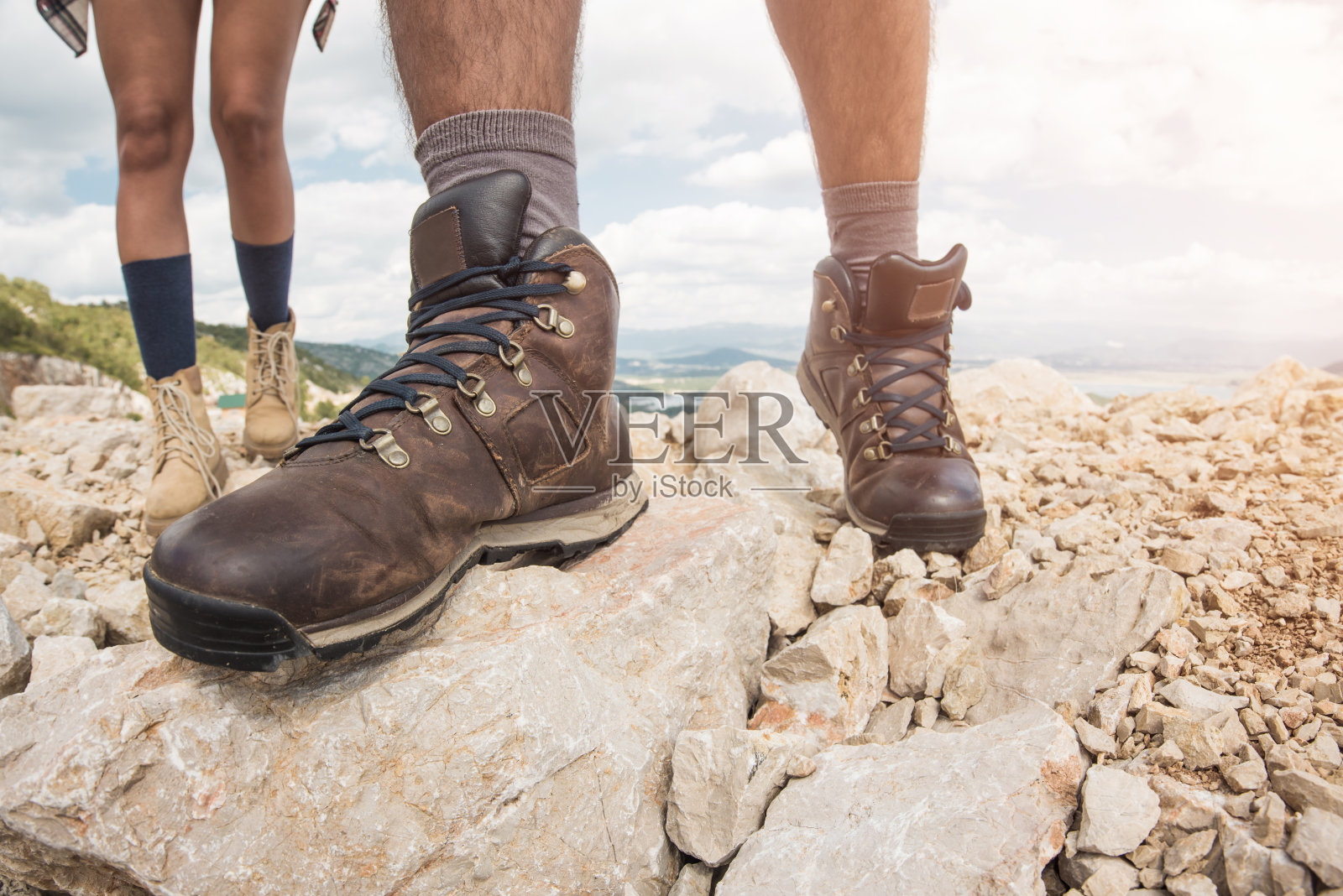 穿着登山靴走在岩石地上。照片摄影图片