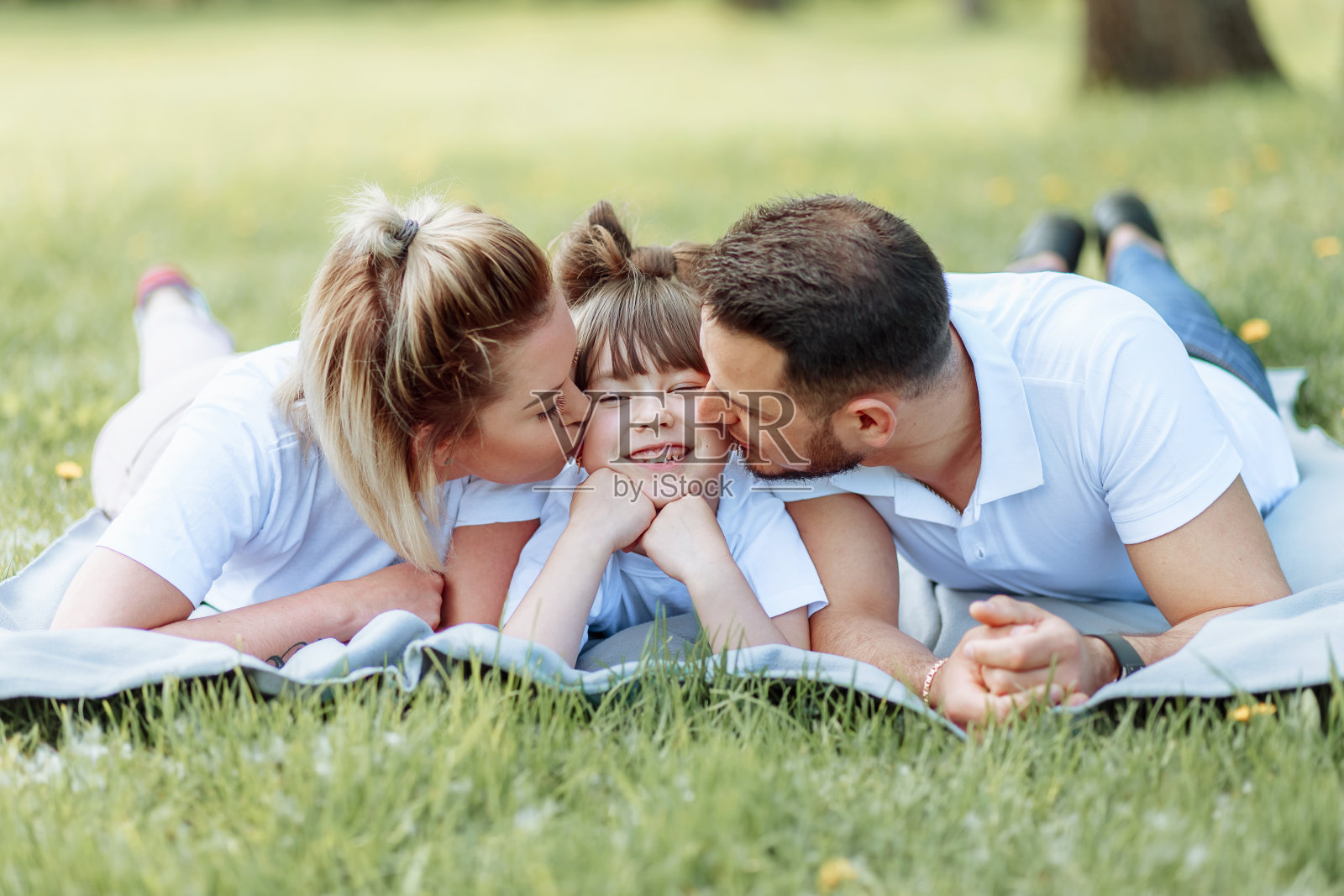 家庭生活幸福和谐。幸福的家庭的概念。年轻的父母和他们的女儿在公园里。幸福的家庭。无忧无虑,百福莱。照片摄影图片