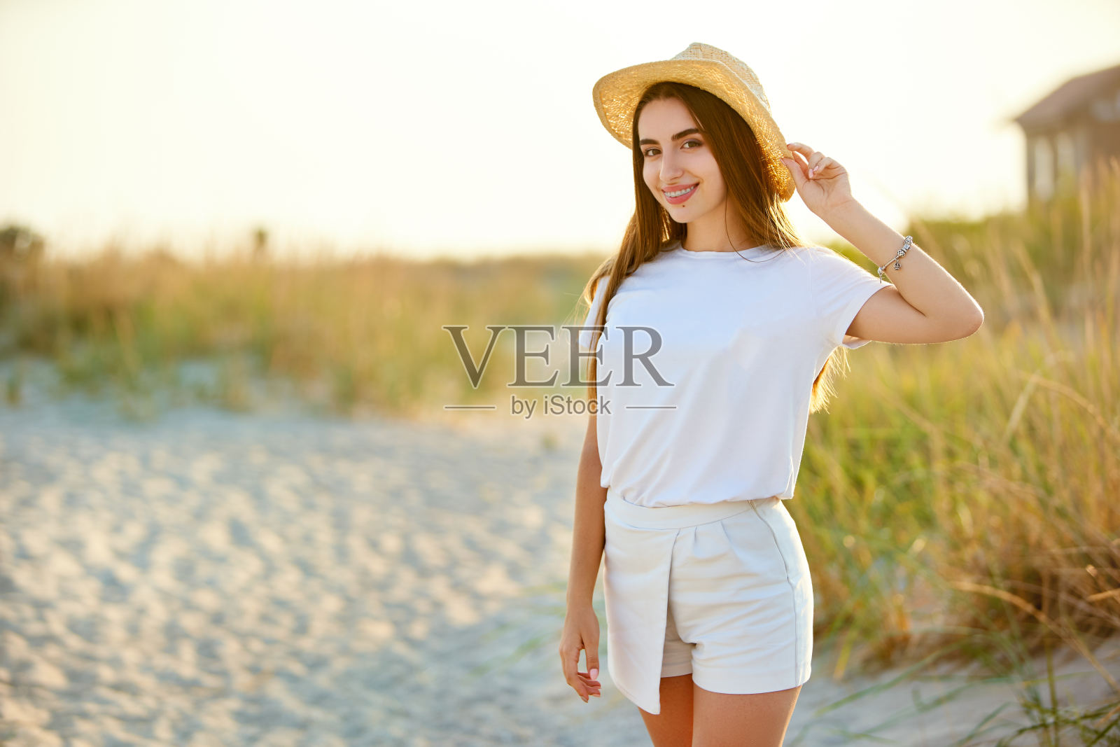 水疗健康海滩美女放松和日光浴在海滩上。美丽安详的年轻女模特戴着牙套在度假旅游胜地享受假期。防晒的概念照片摄影图片
