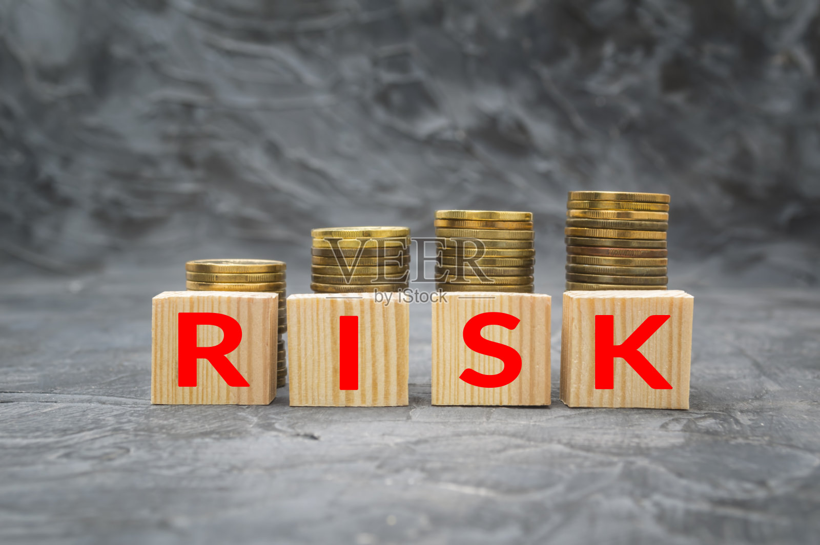 木块上有“风险”和“钱”两个字，背景为黑色。财政债务减少概念。照片摄影图片