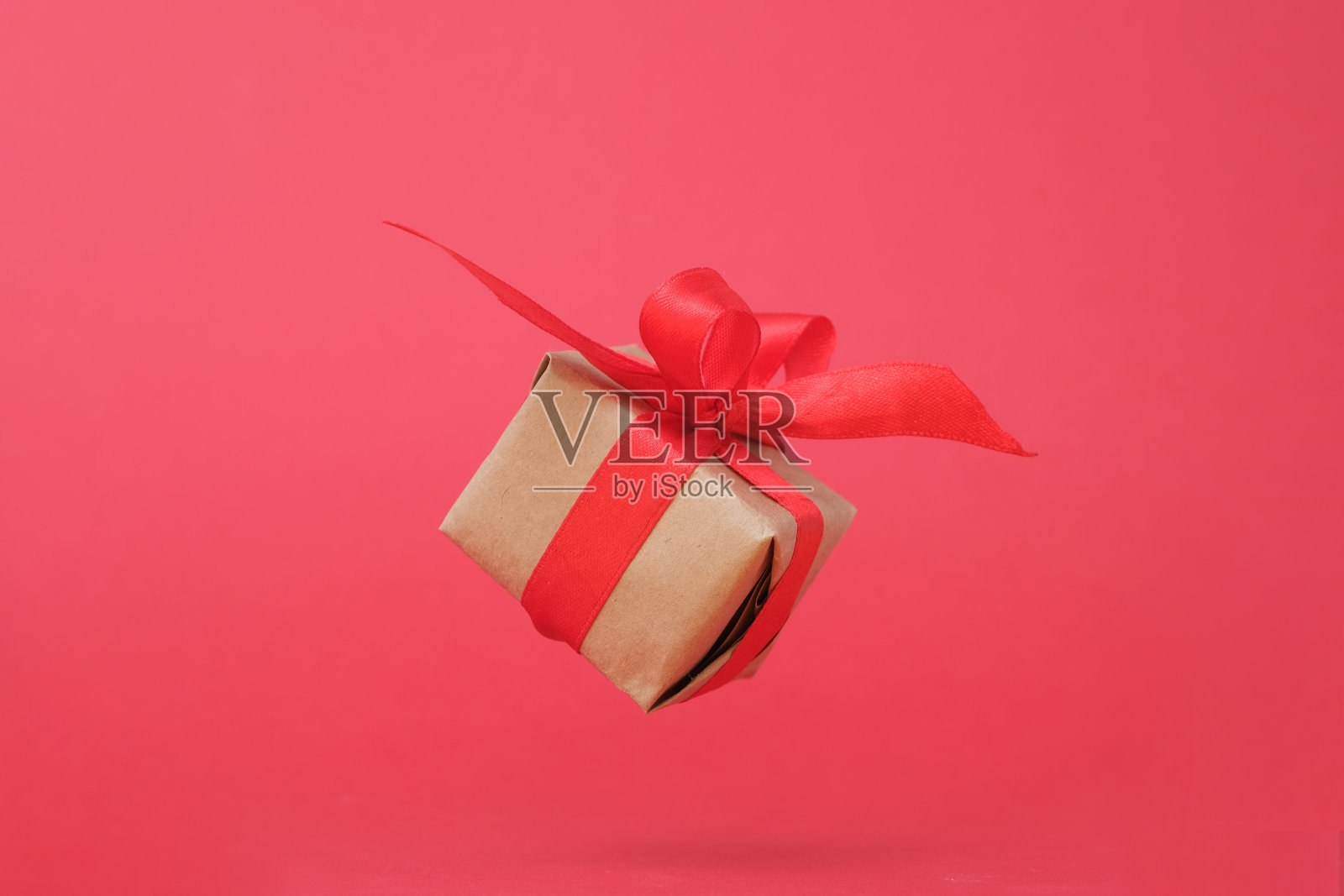 红底红丝带礼盒。零重力。悬浮。milimalism。概念销售，购物，圣诞假期和生日照片摄影图片