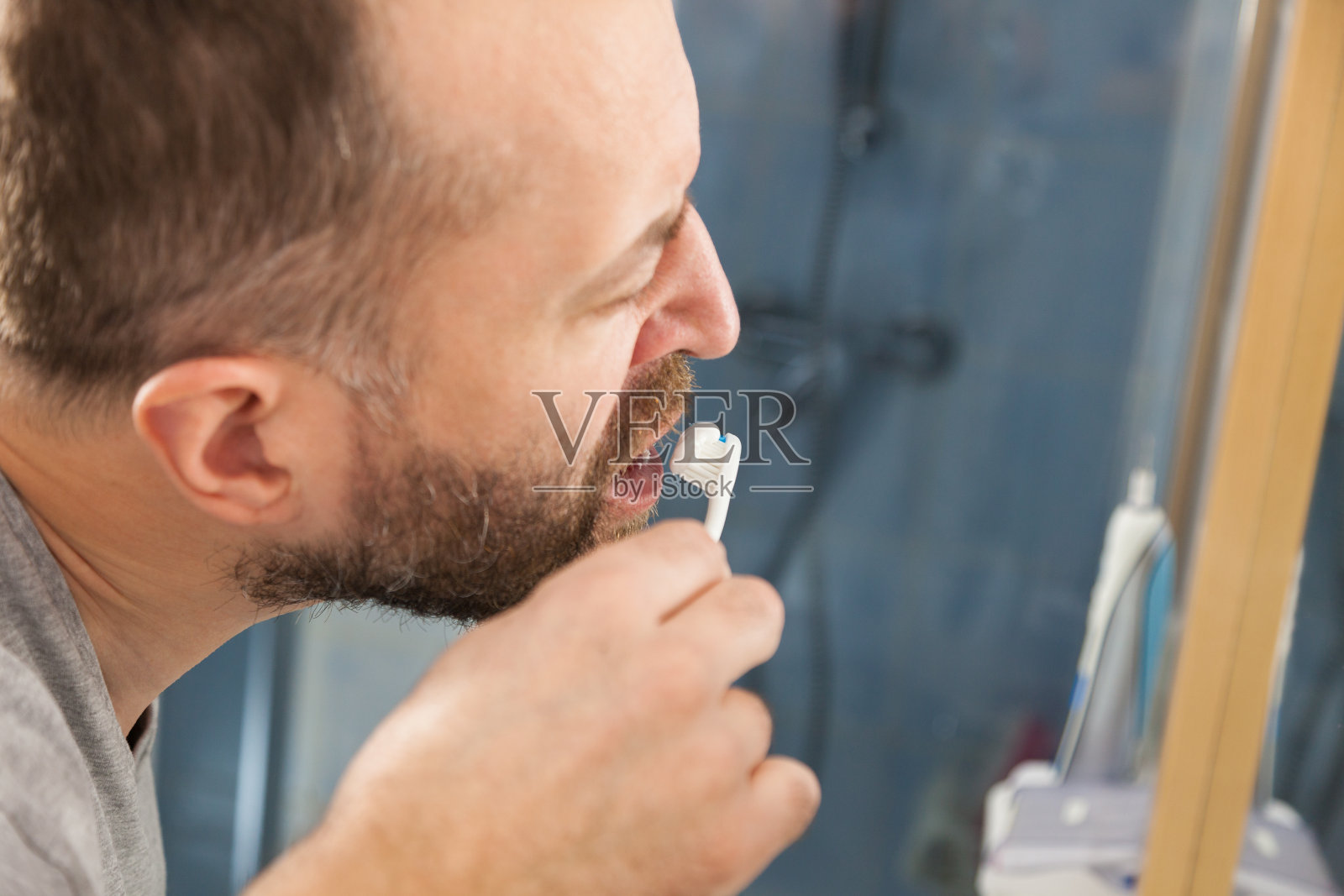 一个男人在浴室里刷牙照片摄影图片
