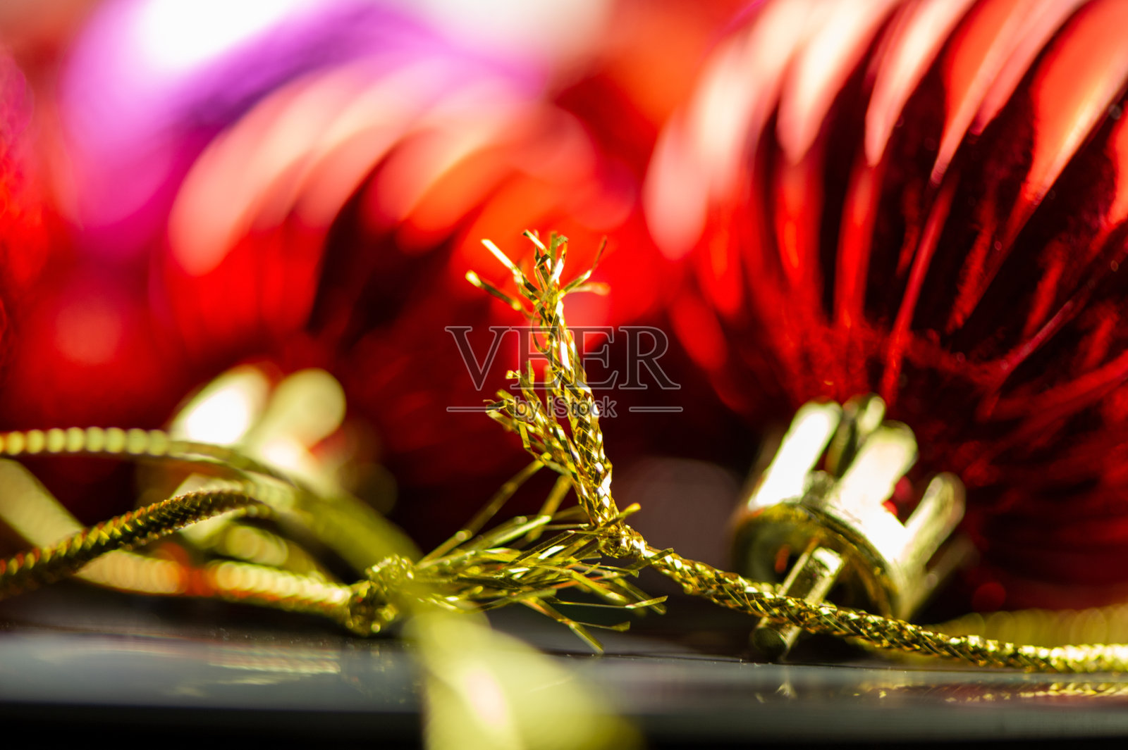 金色的绳子和模糊的圣诞球红色的球。照片摄影图片