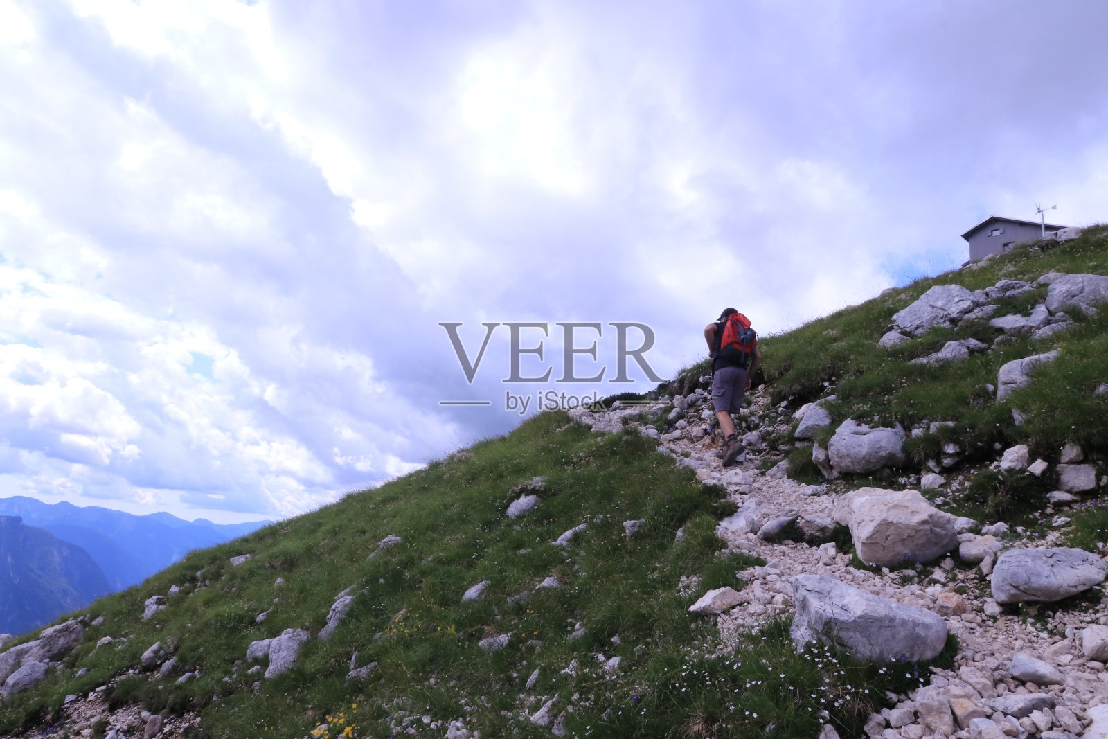 一名男子在斯洛文尼亚朱利安阿尔卑斯山道的岩石上徒步旅行照片摄影图片